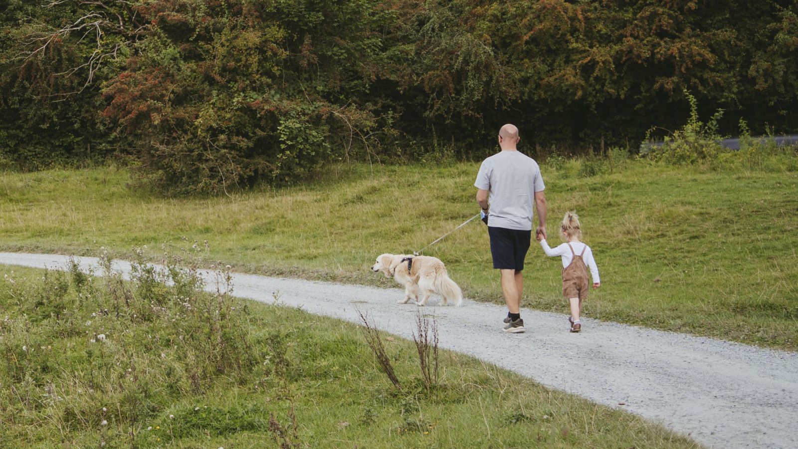 Far og datter går tur med hund i Madsbyparken
