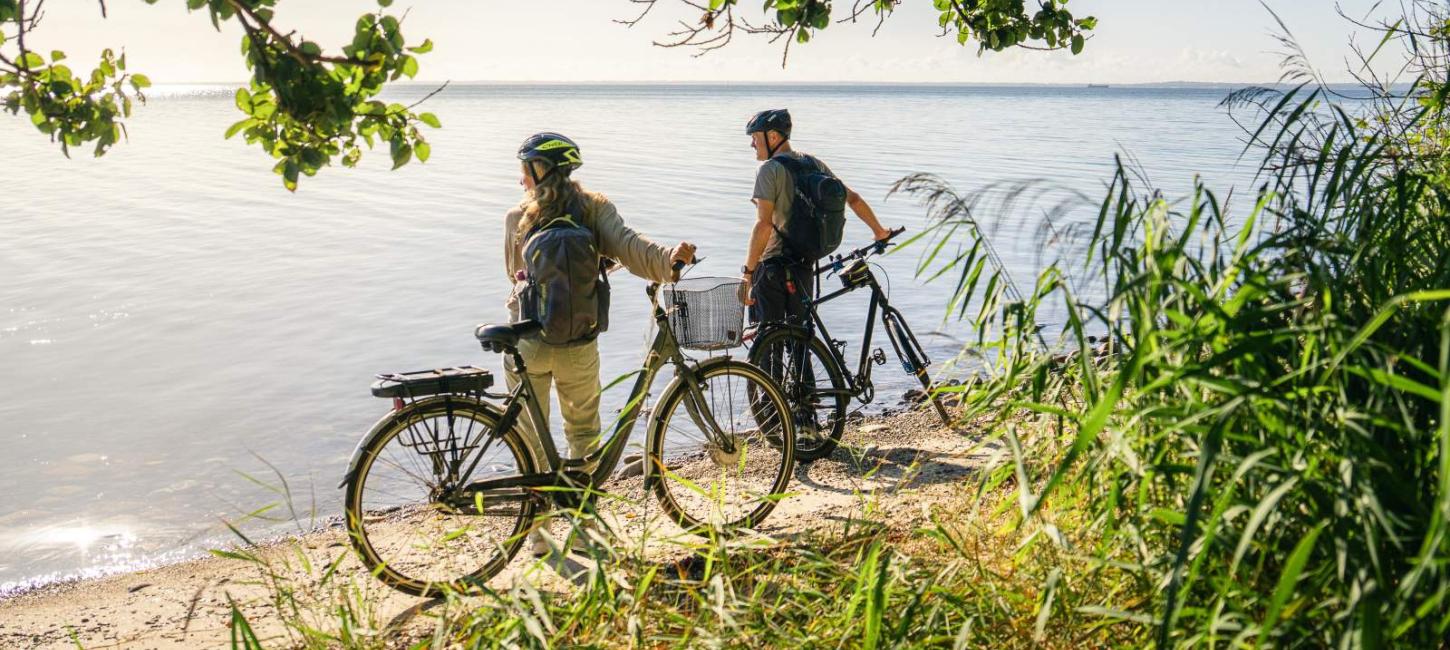 Par på cykelferie betragter kysten